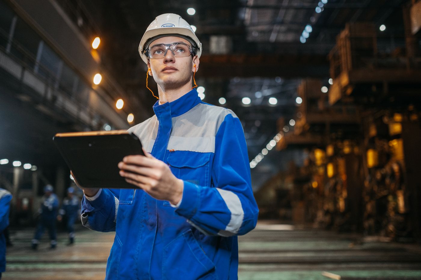Engineer using a tablet on an industrial production line